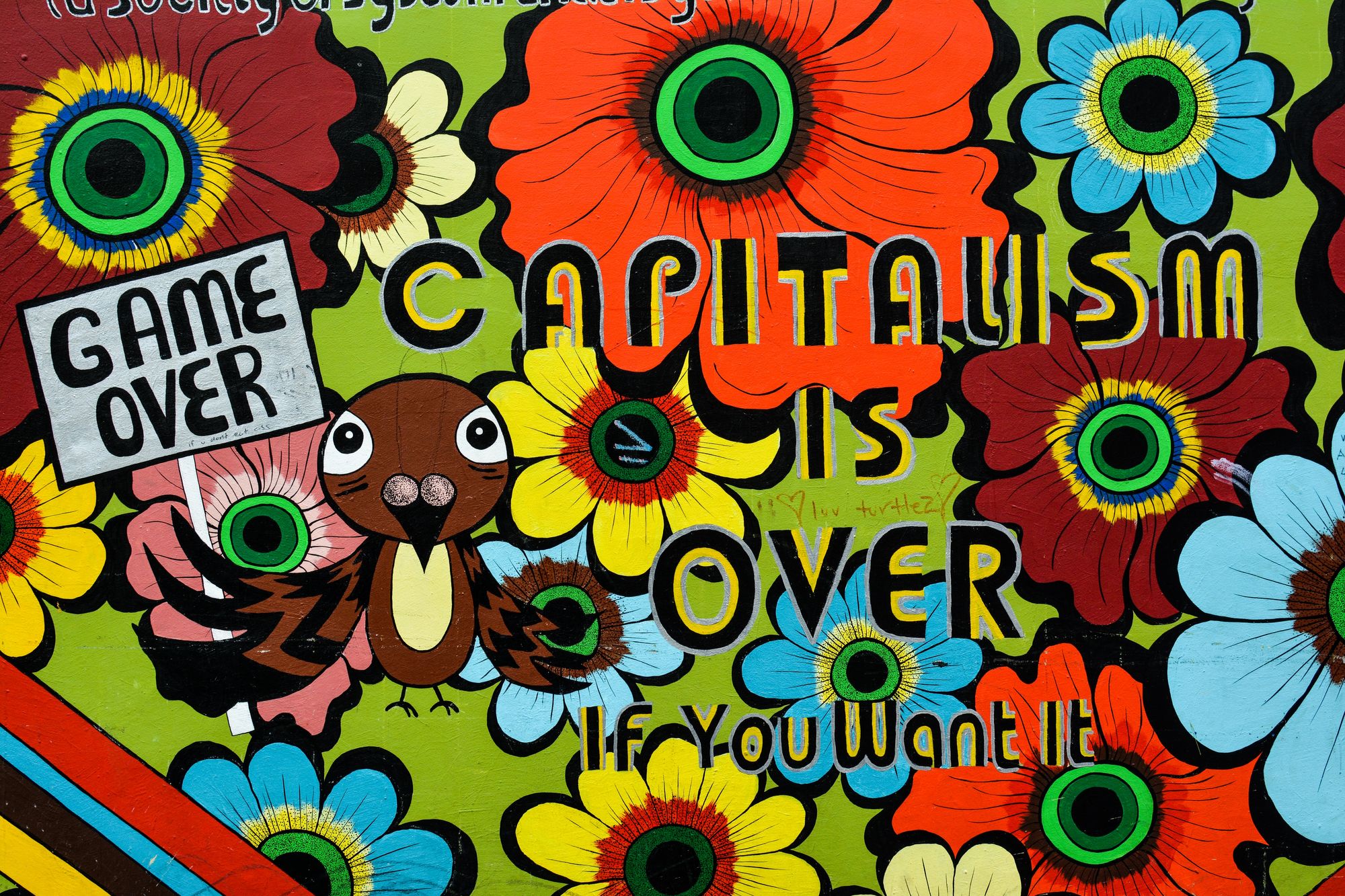 An illustration of flowers and a bird holding a sign reading "game over," with the words "Capitalism is over if you want it."