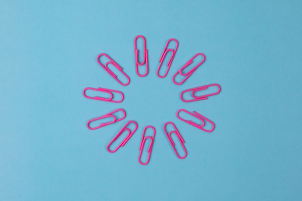 Plastic paper clips arranged in a circle against a blue background