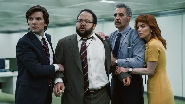 Four office workers (from the Apple TV+ show "Severance") hold each other and look concerned