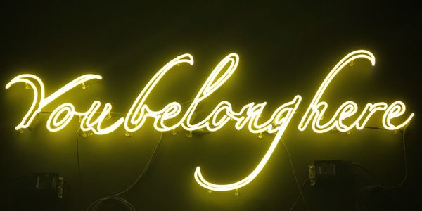 a neon sign reading "you belong here"
